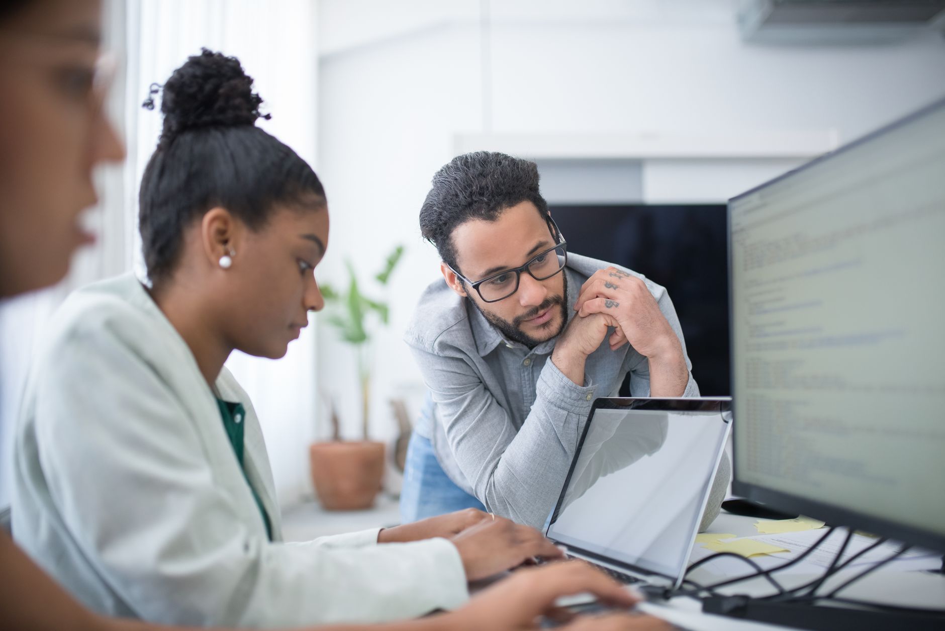 Dois colegas a trabalhar no mesmo monitor, num escritório